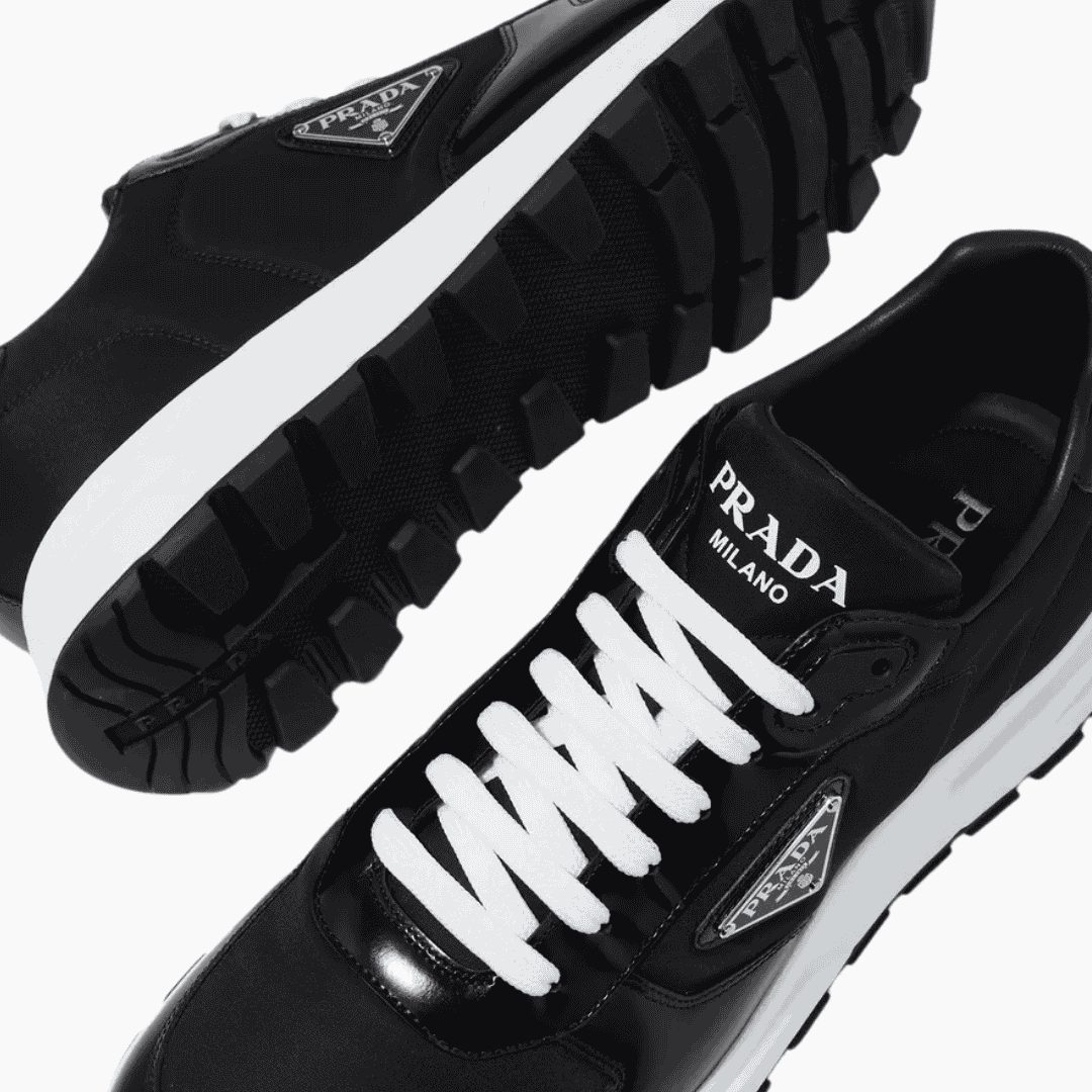 prada-triangle-logo-metal-detail-closeup شعار برادا ثلاثي الزوايا المعدني على حذاء رياضي - تفصيل أصلي.